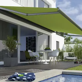 Grüne Markise über Terrasse am Haus, Sonnenschutz am Pool im Garten